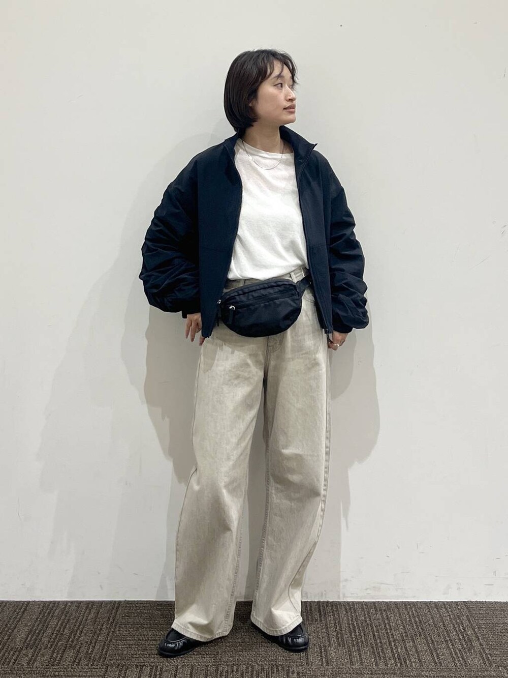 ホワイト系のTシャツ/カットソー、ベージュ系のデニムパンツ、ブラック系のボディバッグ/ウエストポーチを着用したレディースの春コーディネートの2枚目の写真