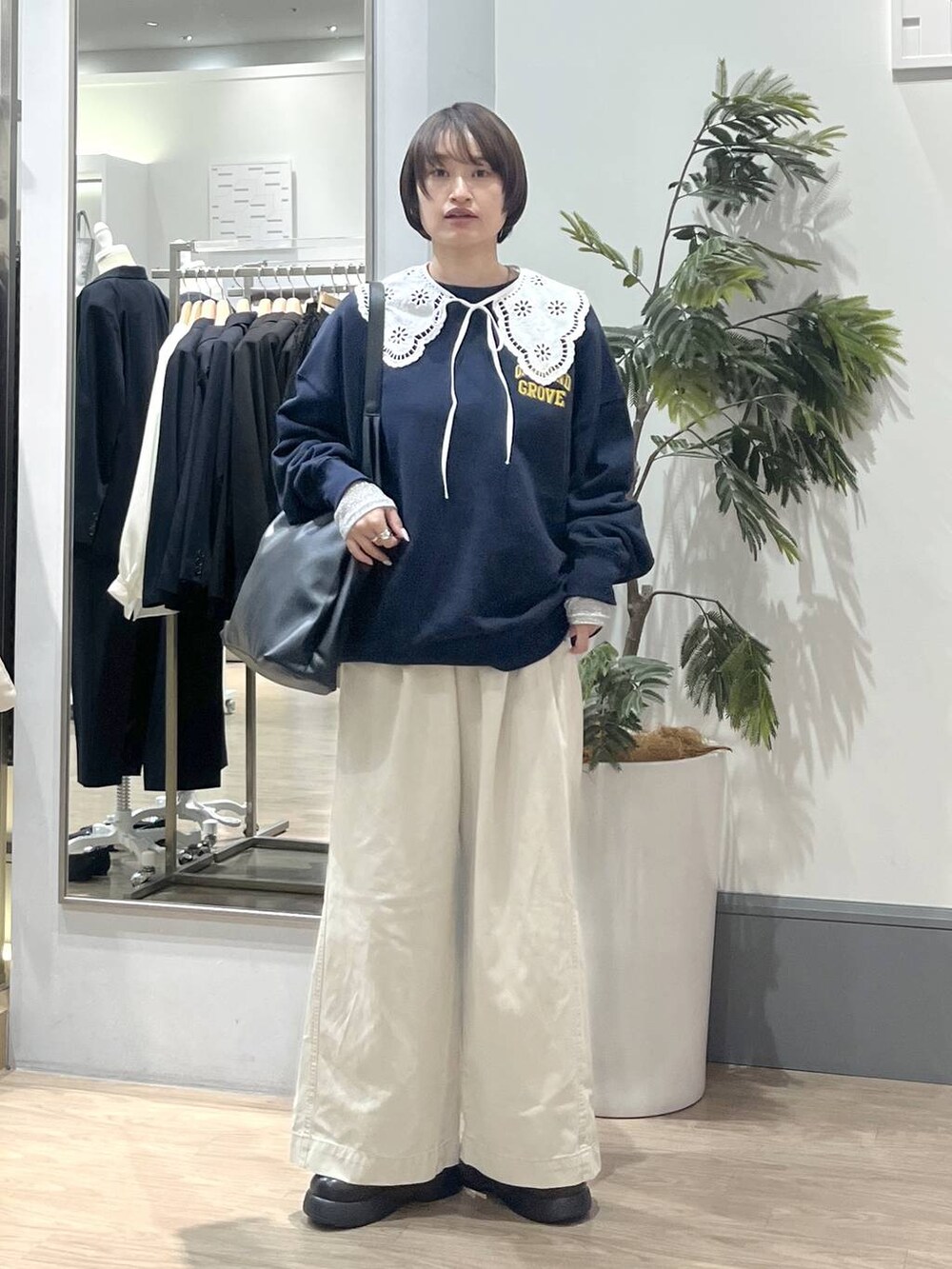 ブラック系のショルダーバッグ、ホワイト系のTシャツ/カットソー、ホワイト系のデニムパンツを着用したレディースの冬コーディネートの2枚目の写真