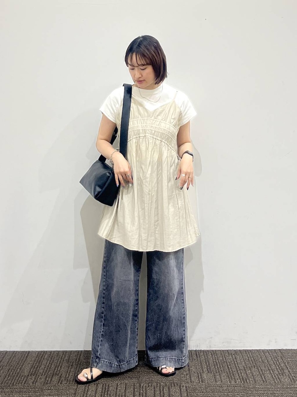 ベージュ系のワンピース、ブラック系のデニムパンツ、ホワイト系のTシャツ/カットソーを着用したレディースの夏コーディネートの3枚目の写真