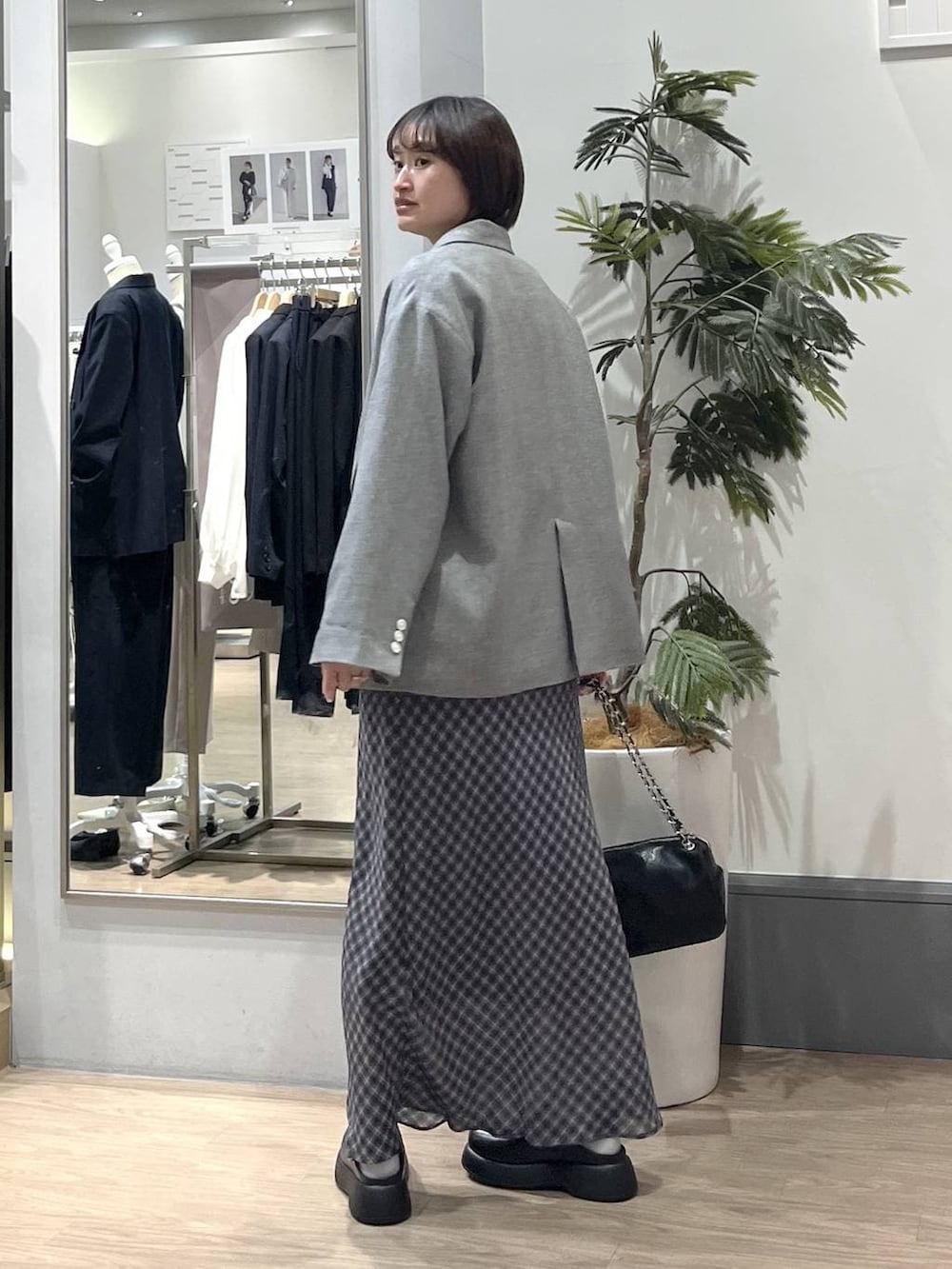 グレー系のテーラードジャケット、ブラック系のショルダーバッグ、ブラック系のサンダルを着用したレディースの春コーディネートの5枚目の写真