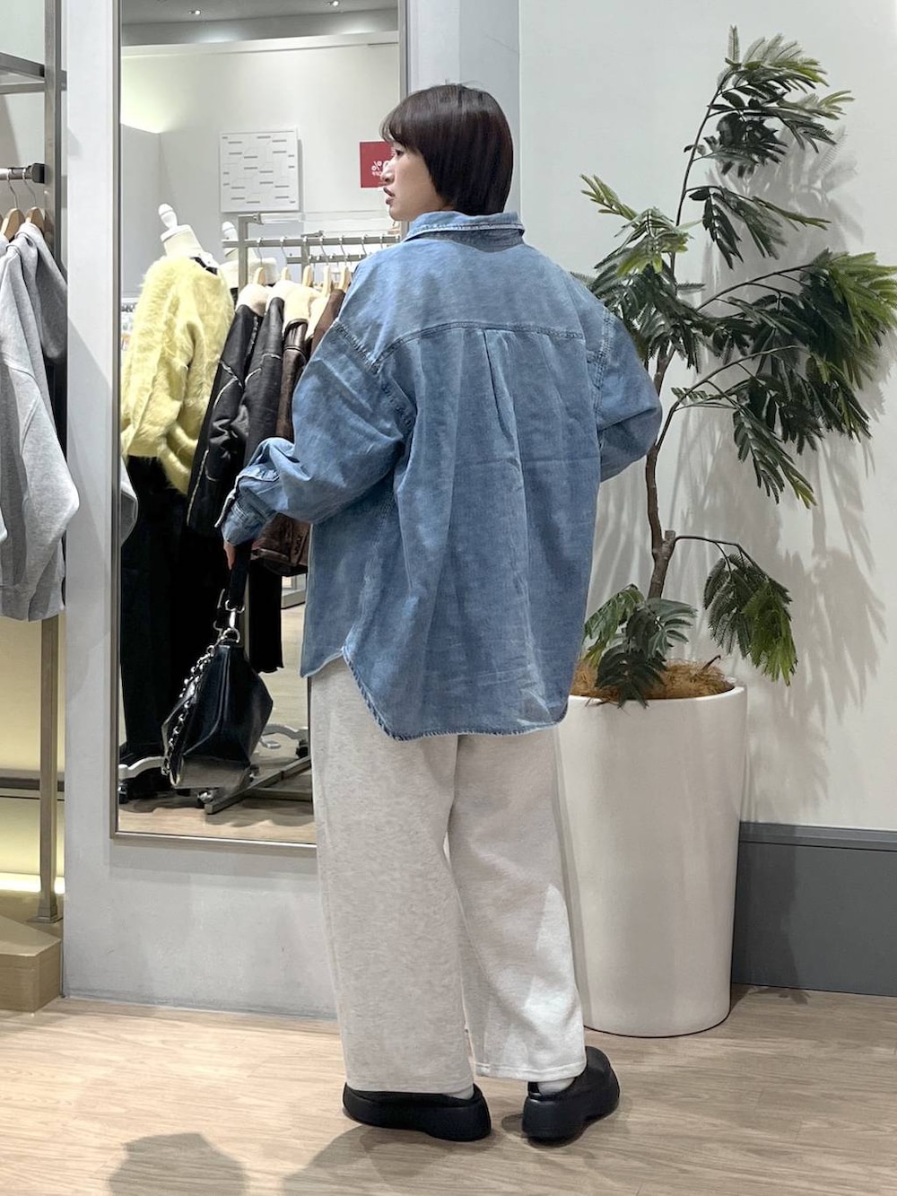 グレー系のスウェットパンツ、ブルー系のシャツ/ブラウス、ブラック系のショルダーバッグを着用したレディースの冬コーディネートの4枚目の写真