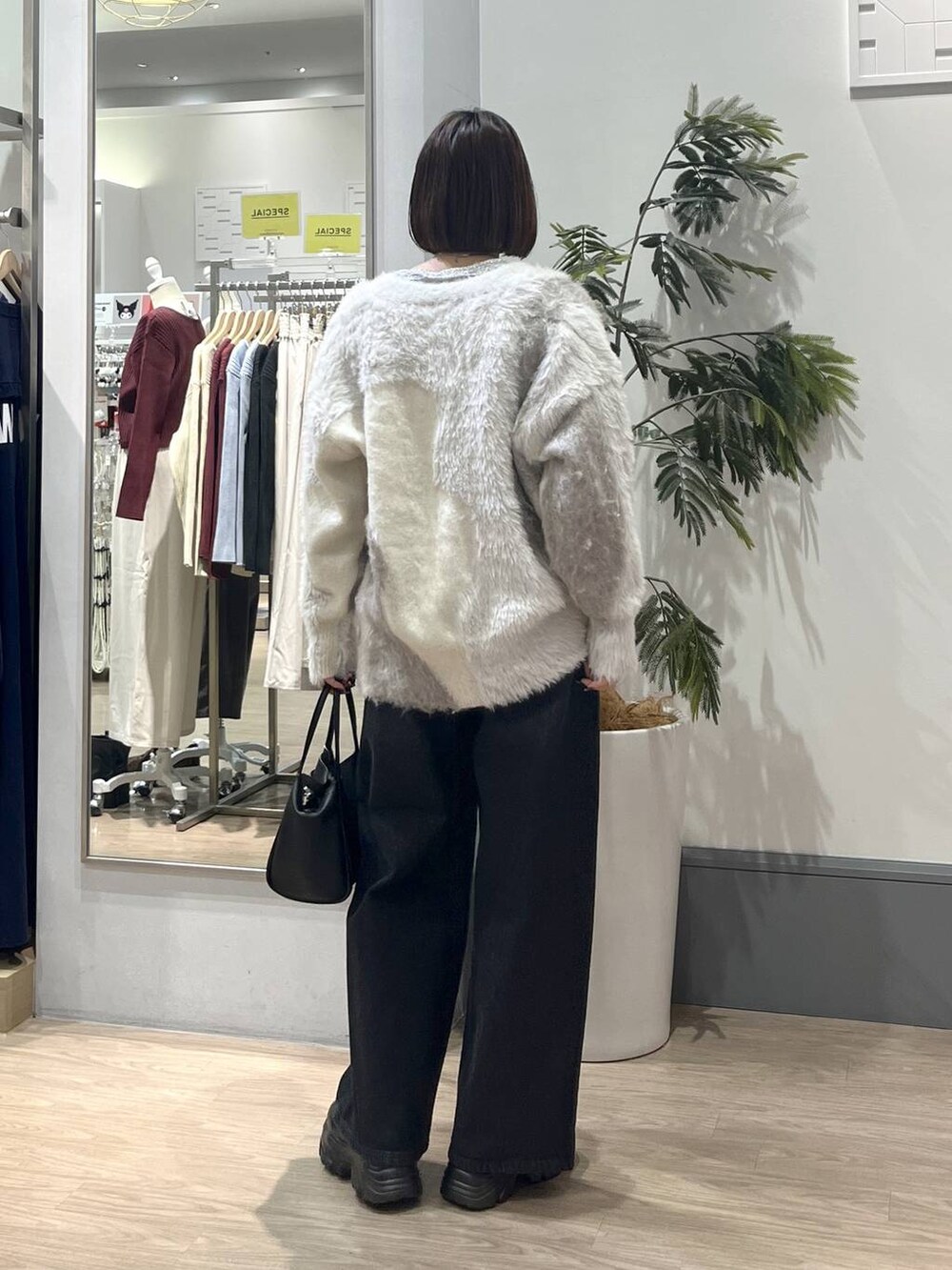 ブラック系のブーツ、ホワイト系のカーディガン/ボレロ、ホワイト系のTシャツ/カットソーを着用したレディースの秋コーディネートの5枚目の写真