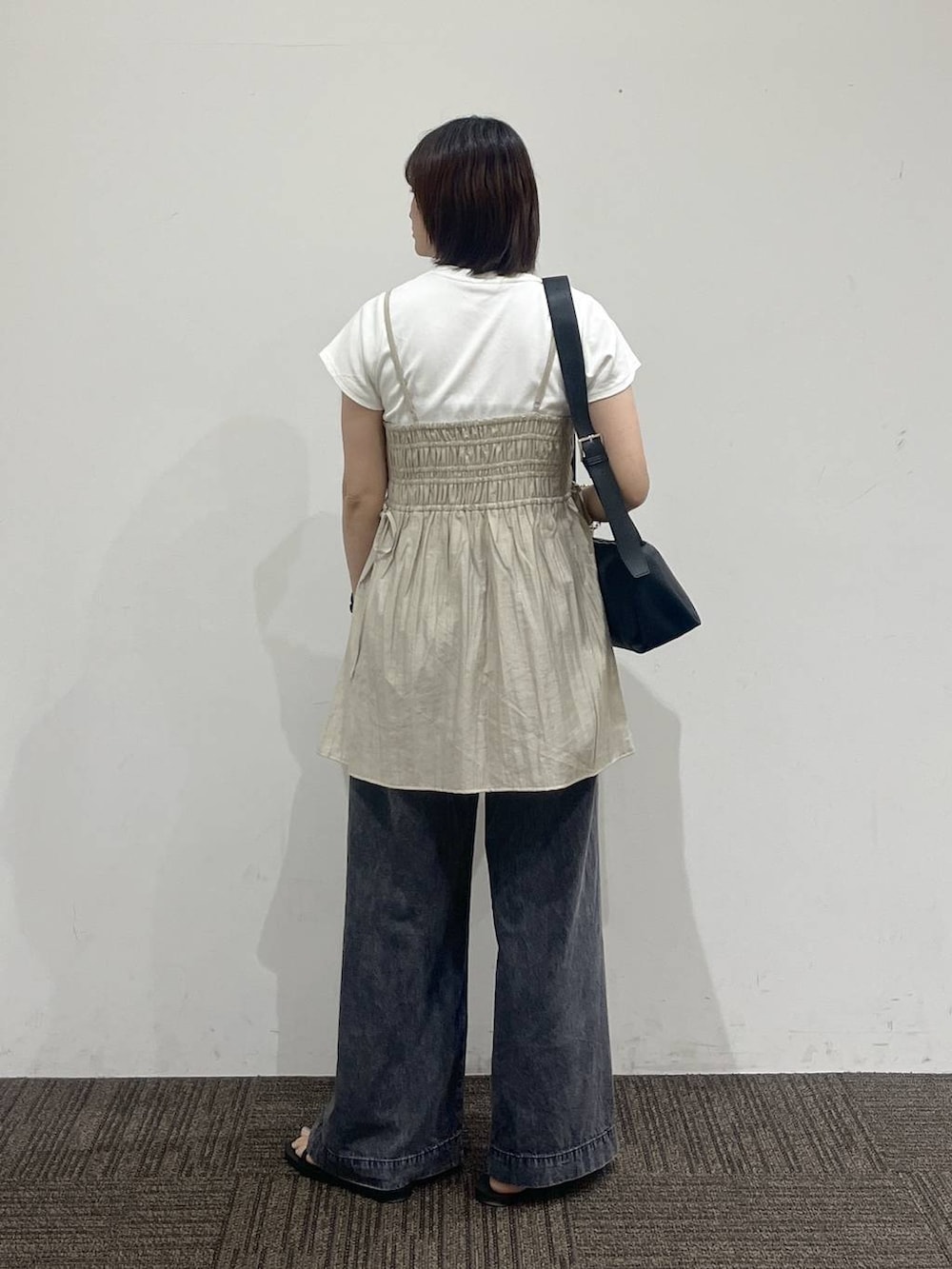 ベージュ系のワンピース、ブラック系のデニムパンツ、ホワイト系のTシャツ/カットソーを着用したレディースの夏コーディネートの4枚目の写真