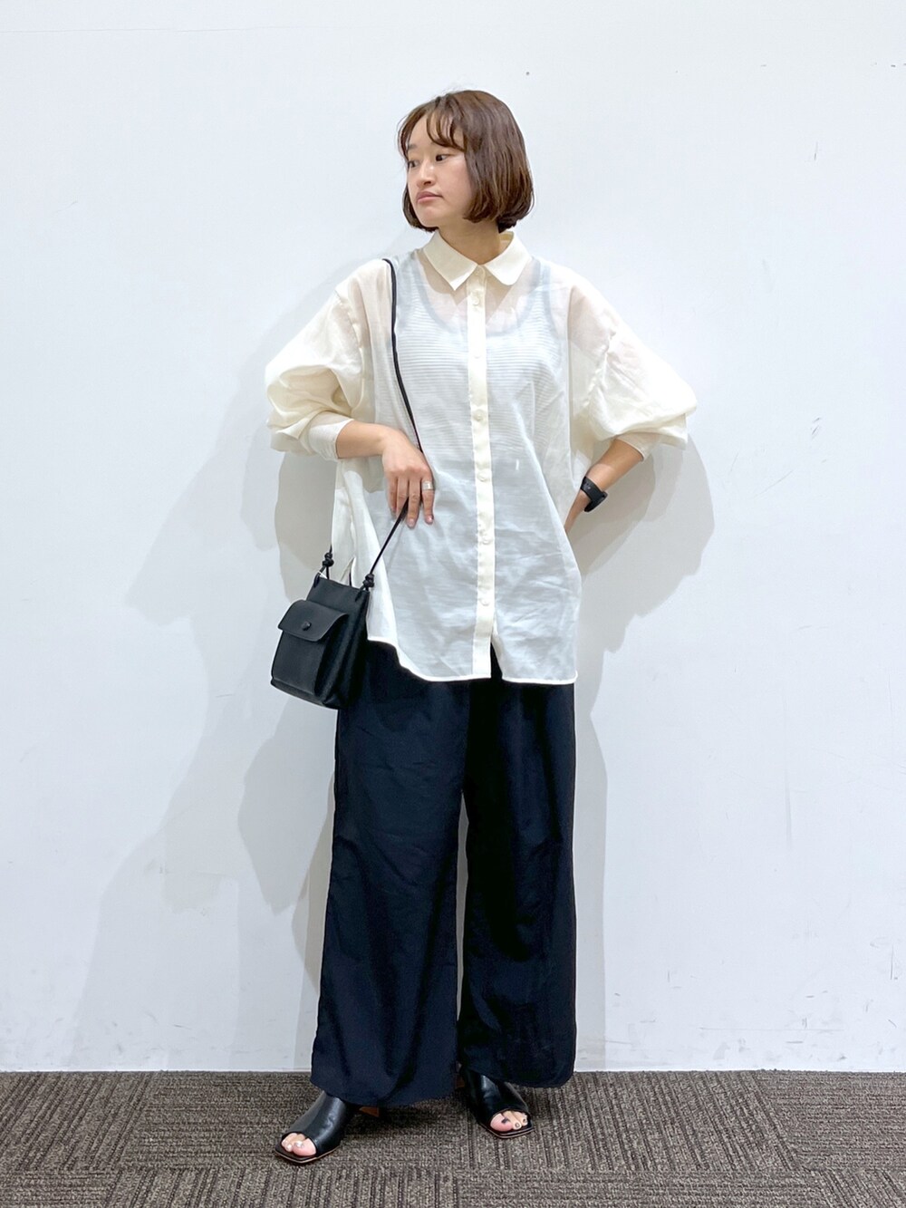 ブラック系のパンツ、ブラック系のトップス、ホワイト系のトップスを着用したレディースの春コーディネートの2枚目の写真