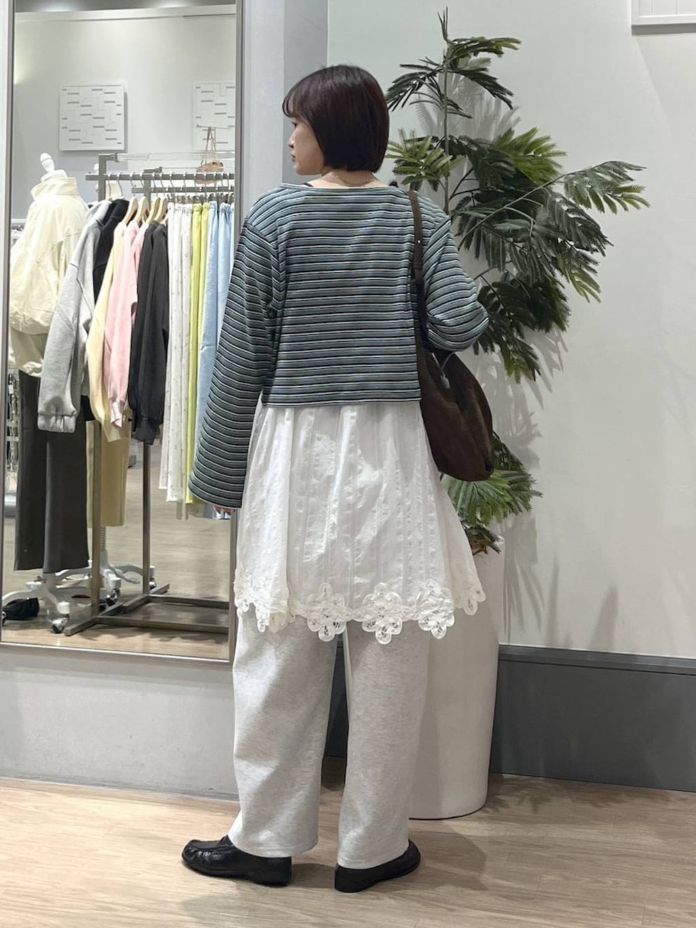 ブラック系のTシャツ/カットソー、グレー系のスウェットパンツ、ブラック系のローファーを着用したレディースの春コーディネートの4枚目の写真