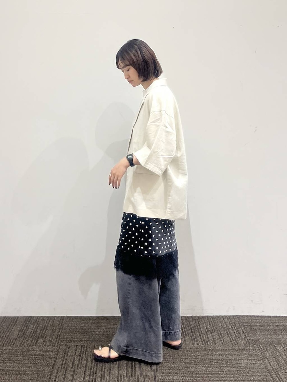 ブラック系のデニムパンツ、ホワイト系のテーラードジャケット、ホワイト系のTシャツ/カットソーを着用したレディースの夏コーディネートの3枚目の写真