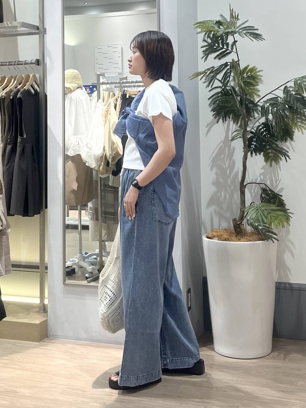 ブルー系のデニムパンツ、ブルー系のシャツ/ブラウス、ホワイト系のTシャツ/カットソーを着用したレディースの夏コーディネートの3枚目の写真