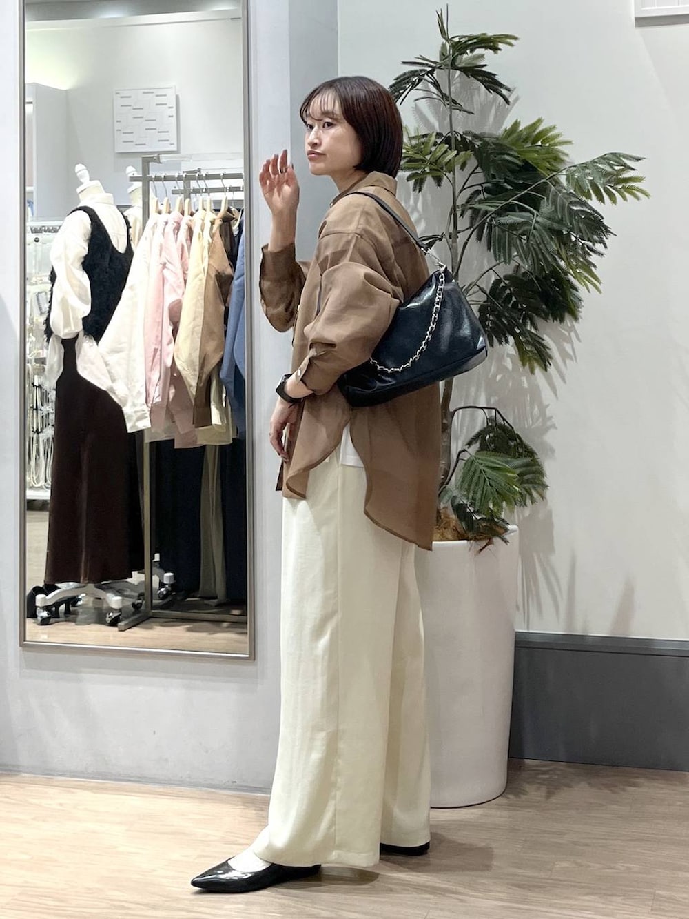 ホワイト系のTシャツ/カットソー、ブラック系のパンプス、ブラウン系のシャツ/ブラウスを着用したレディースの春コーディネートの4枚目の写真