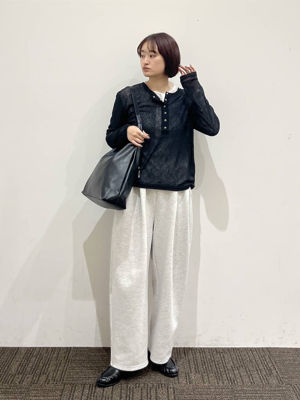 ブラック系のショルダーバッグ、グレー系のスウェットパンツ、ブラック系のローファーを着用したレディースの春コーディネートの2枚目の写真