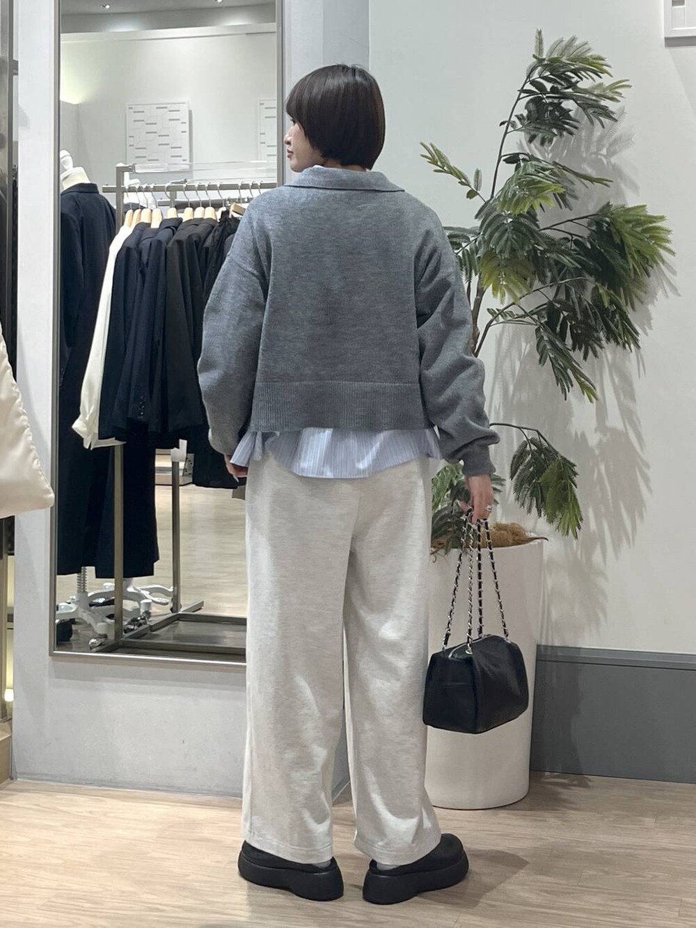 ブラック系のショルダーバッグ、ブラック系のサンダル、ブルー系のシャツ/ブラウスを着用したレディースの冬コーディネートの5枚目の写真