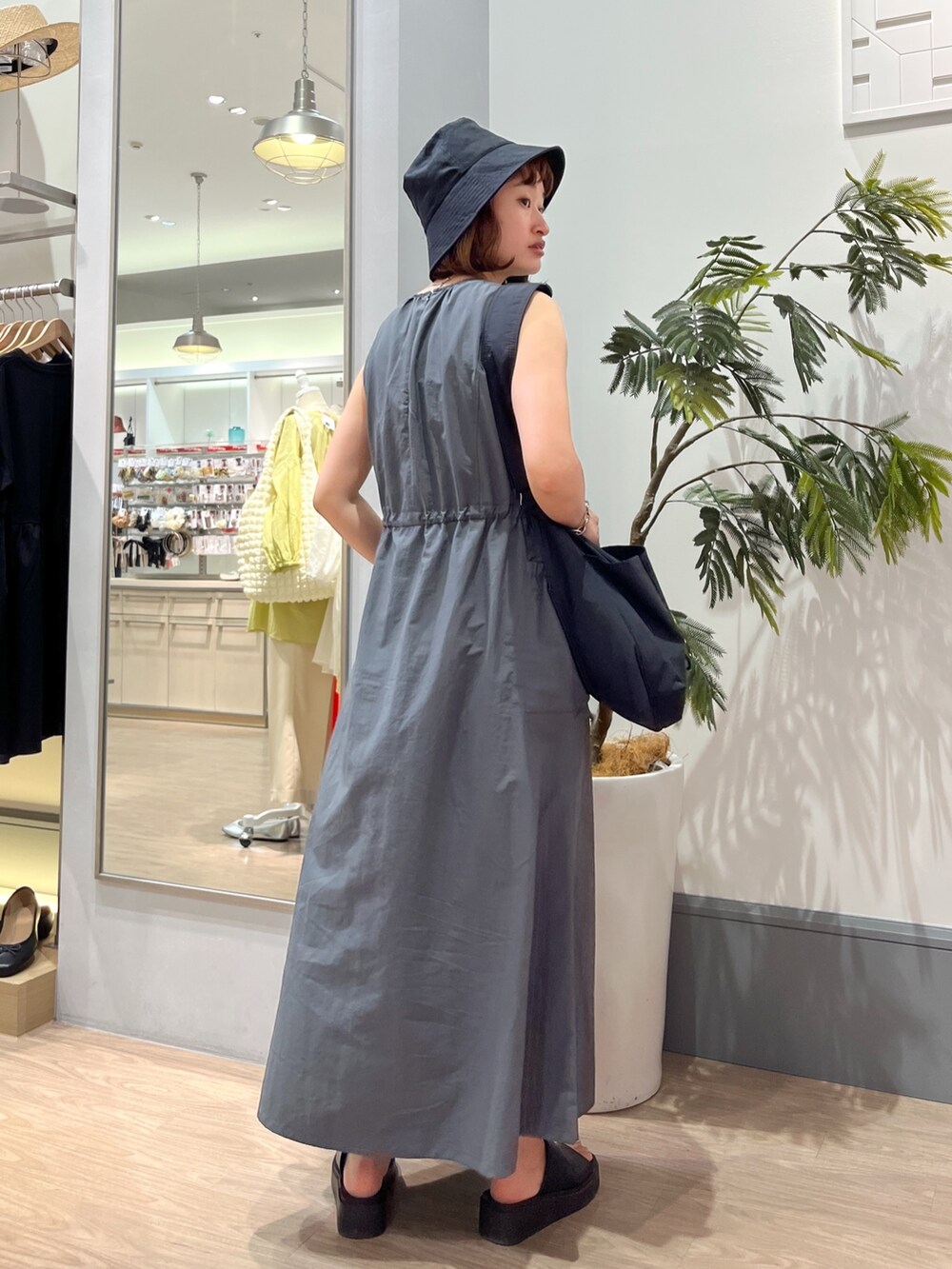 グレー系のワンピース、ブラック系のショルダーバッグ、ブラック系のシューズを着用したレディースの夏コーディネートの3枚目の写真