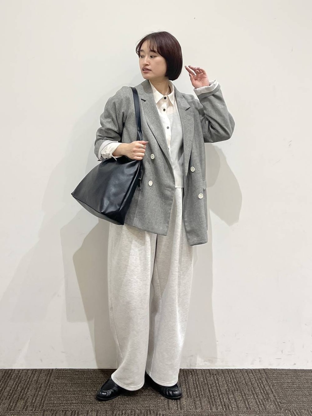 ブラック系のショルダーバッグ、グレー系のスウェットパンツ、グレー系のテーラードジャケットを着用したレディースの春コーディネートの3枚目の写真