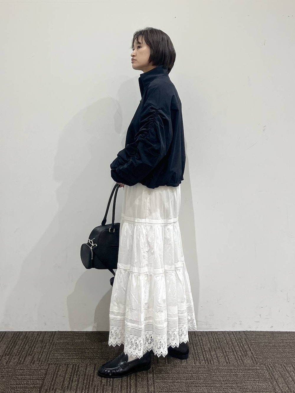 ホワイト系のTシャツ/カットソー、ブラック系のボストンバッグ、ブラック系のローファーを着用したレディースの春コーディネートの3枚目の写真