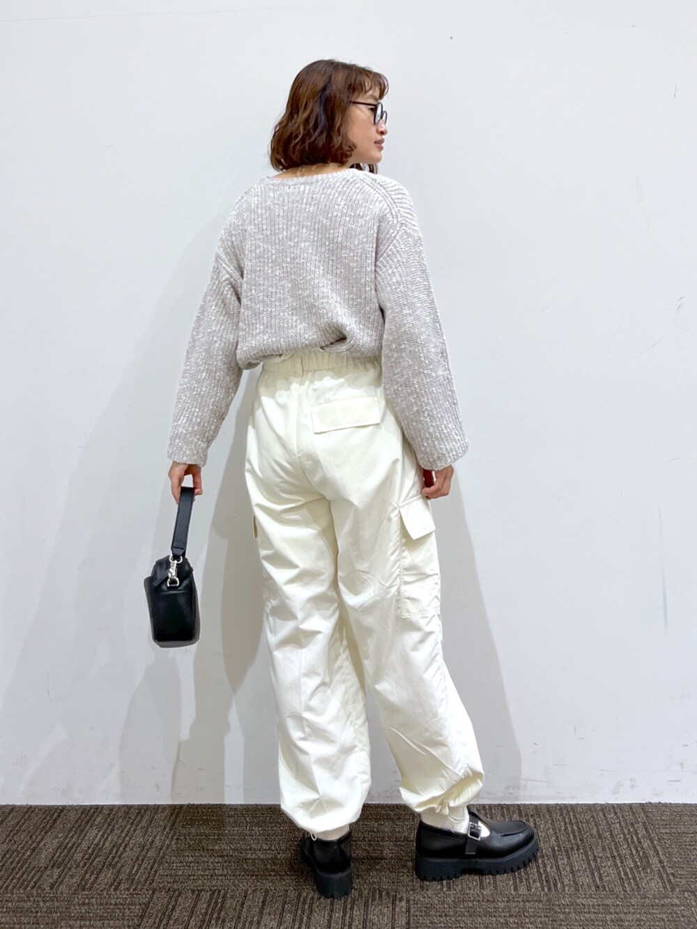 ブラック系のローファー、ブラック系のショルダーバッグ、ホワイト系のカーゴパンツを着用したレディースの冬コーディネートの3枚目の写真