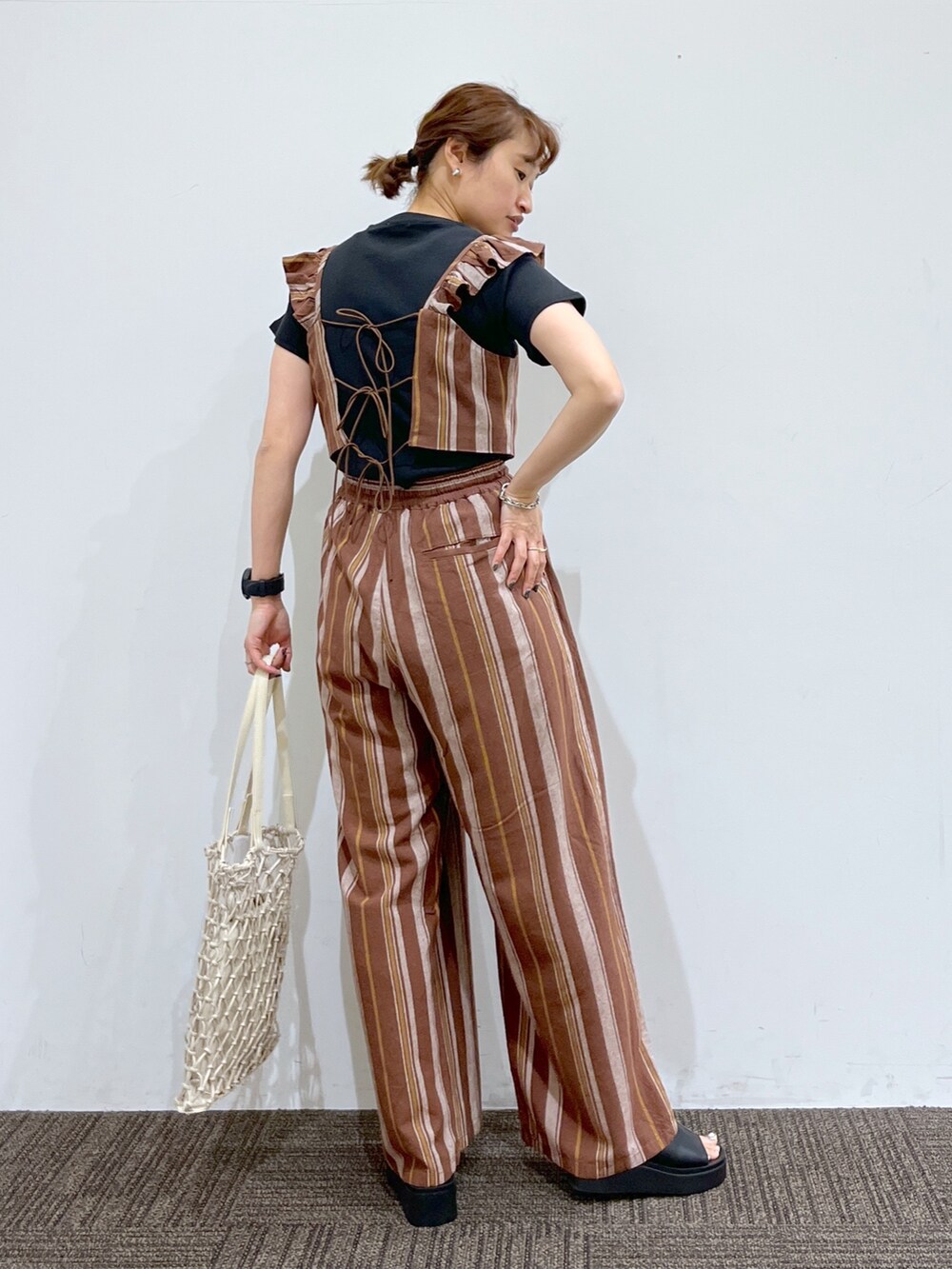 ブラック系のシューズ、ホワイト系のバッグ、ブラウン系のその他パンツを着用したレディースの春コーディネートの3枚目の写真