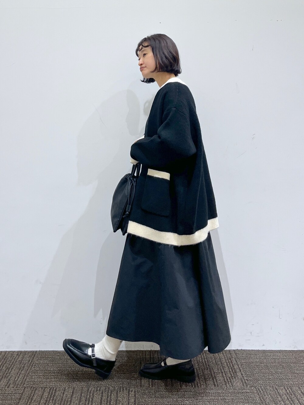 ブラック系のドレスシューズ、ブラック系のショルダーバッグ、ブラック系のワンピースを着用したレディースの秋コーディネートの2枚目の写真