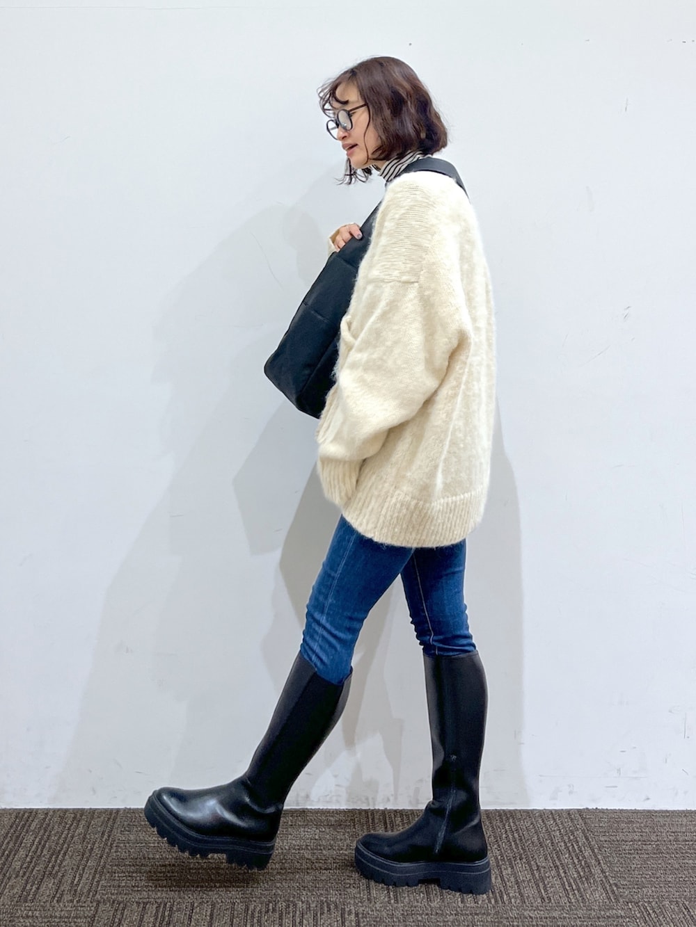 ホワイト系のトップス、ホワイト系のトップス、ブルー系のデニムパンツを着用したレディースの冬コーディネートの4枚目の写真