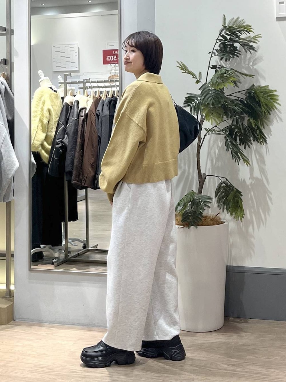 グレー系のスウェットパンツ、ブラック系のショルダーバッグ、ブラック系のローファーを着用したレディースの冬コーディネートの3枚目の写真