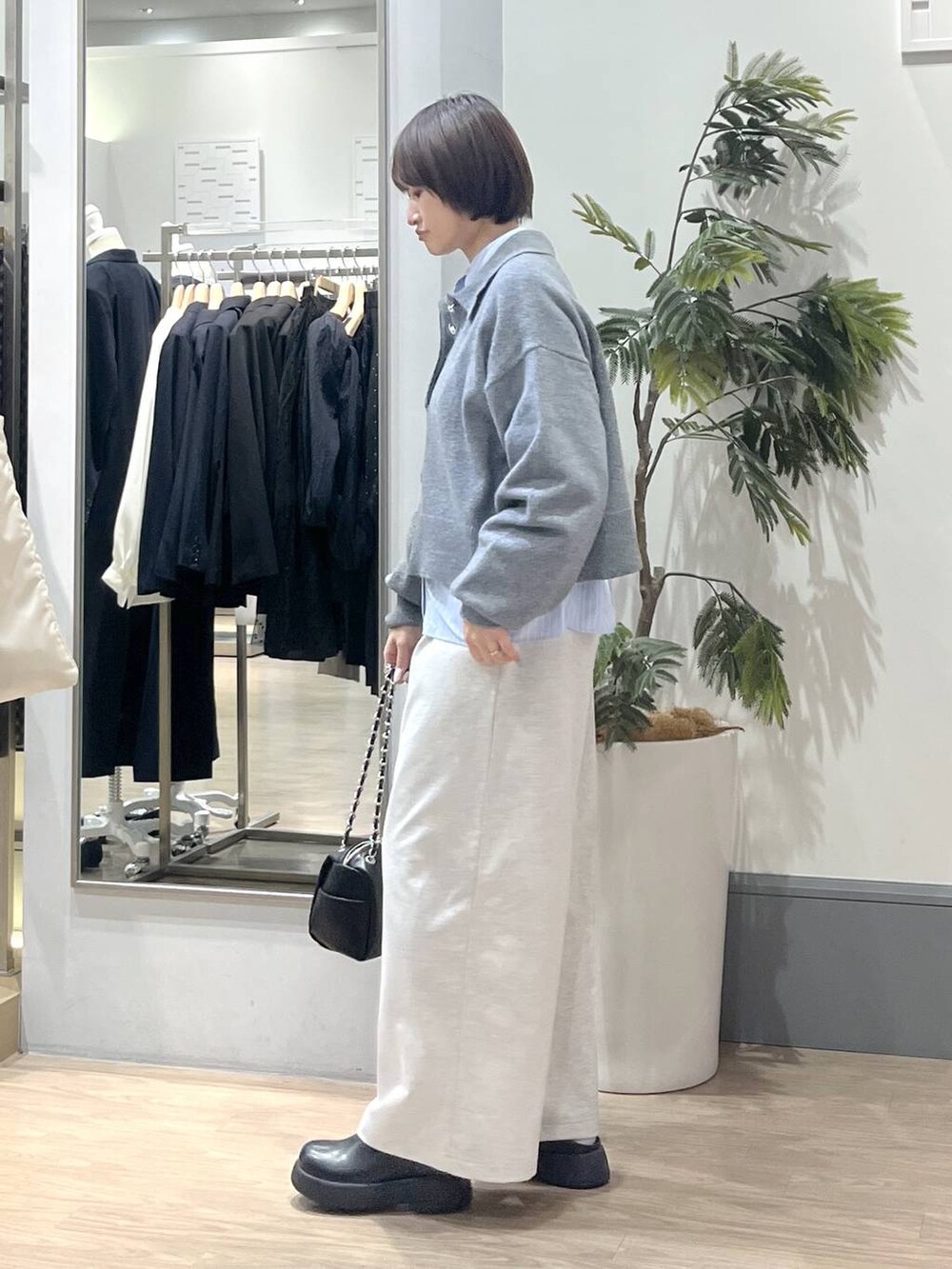 ブラック系のショルダーバッグ、ブラック系のサンダル、ブルー系のシャツ/ブラウスを着用したレディースの冬コーディネートの4枚目の写真