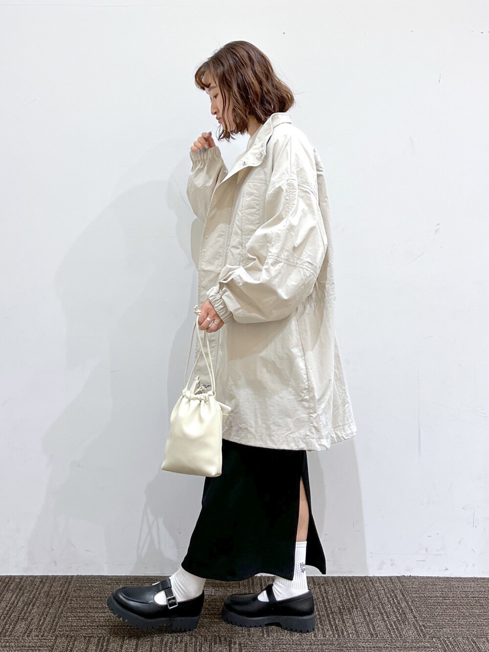 ピンク系のトップス、ホワイト系のトップス、ブラック系のスカートを着用したレディースの冬コーディネートの2枚目の写真