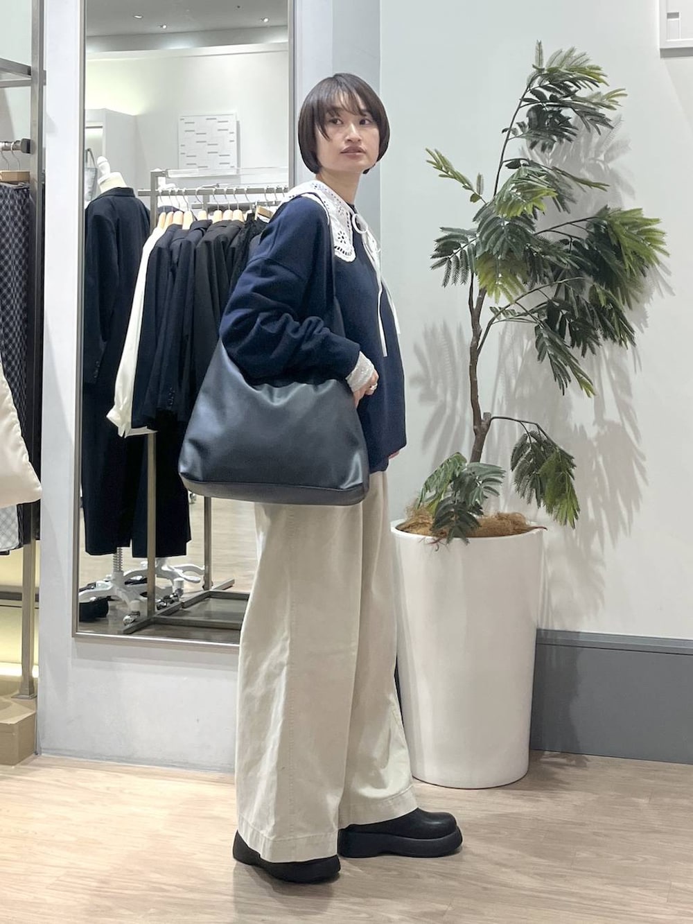 ブラック系のショルダーバッグ、ホワイト系のTシャツ/カットソー、ホワイト系のデニムパンツを着用したレディースの冬コーディネートの3枚目の写真