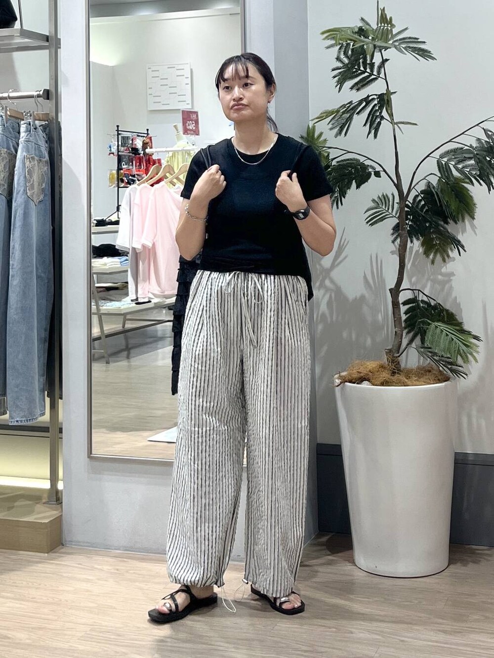 ブラック系のTシャツ/カットソー、ブラック系のサンダル、ブラック系のバックパック/リュックを着用したレディースの夏コーディネートの3枚目の写真
