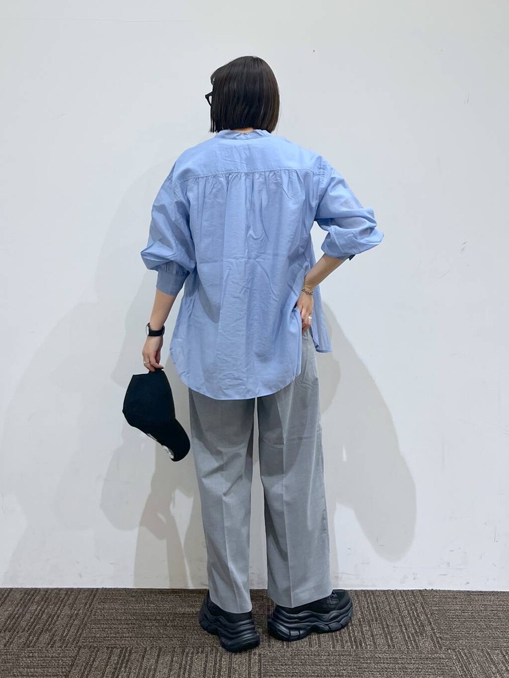 グレー系のスラックス、ブラック系のスニーカー、ホワイト系のTシャツ/カットソーを着用したレディースの春コーディネートの4枚目の写真