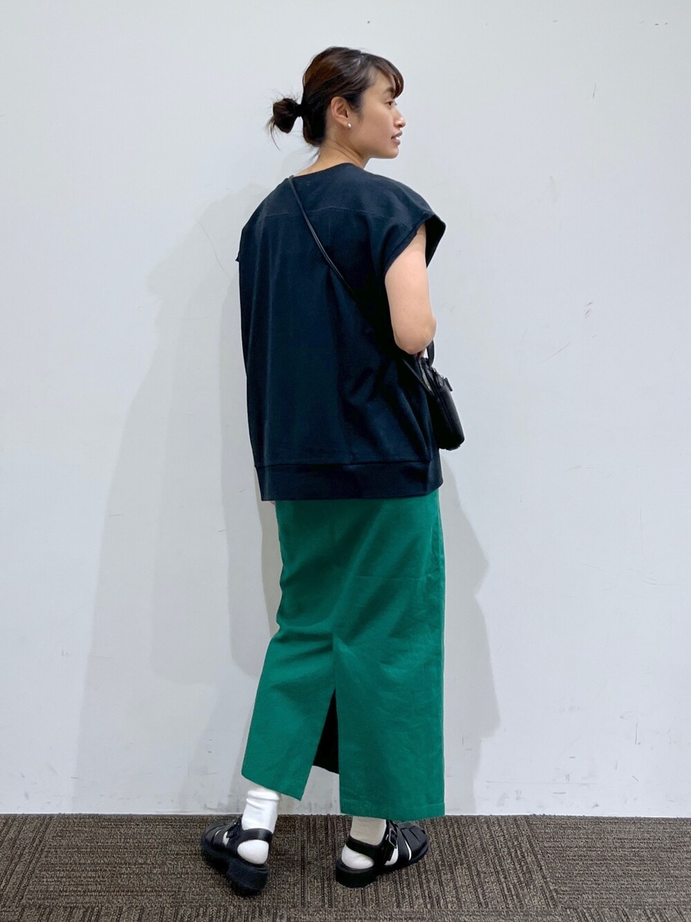 グリーン系のスカート、ブラック系のショルダーバッグ、グレー系のTシャツ/カットソーを着用したレディースの夏コーディネートの3枚目の写真
