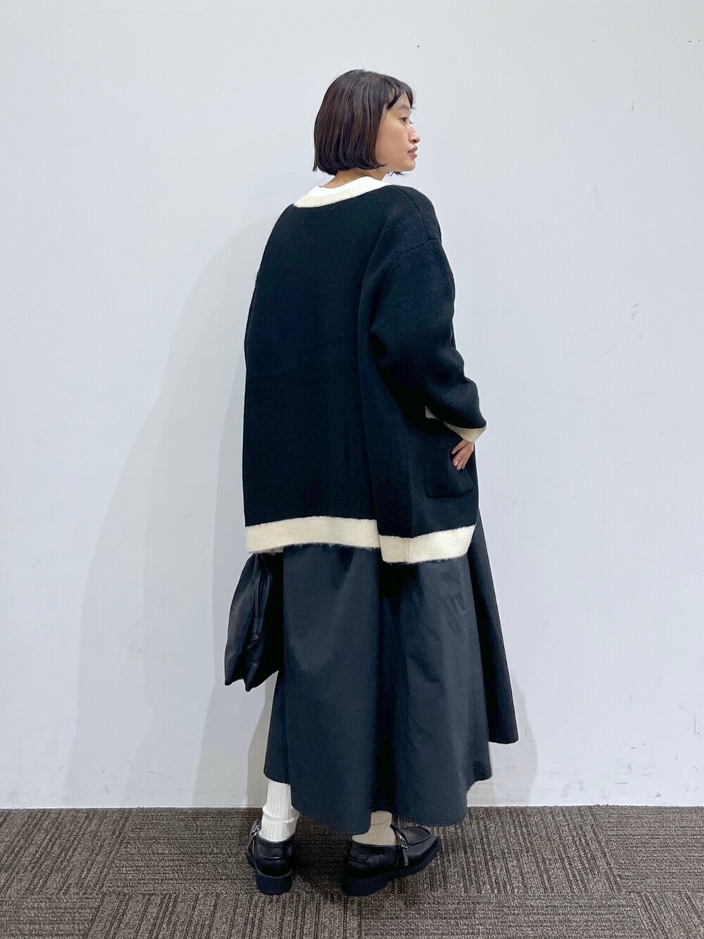 ブラック系のドレスシューズ、ブラック系のショルダーバッグ、ブラック系のワンピースを着用したレディースの秋コーディネートの3枚目の写真