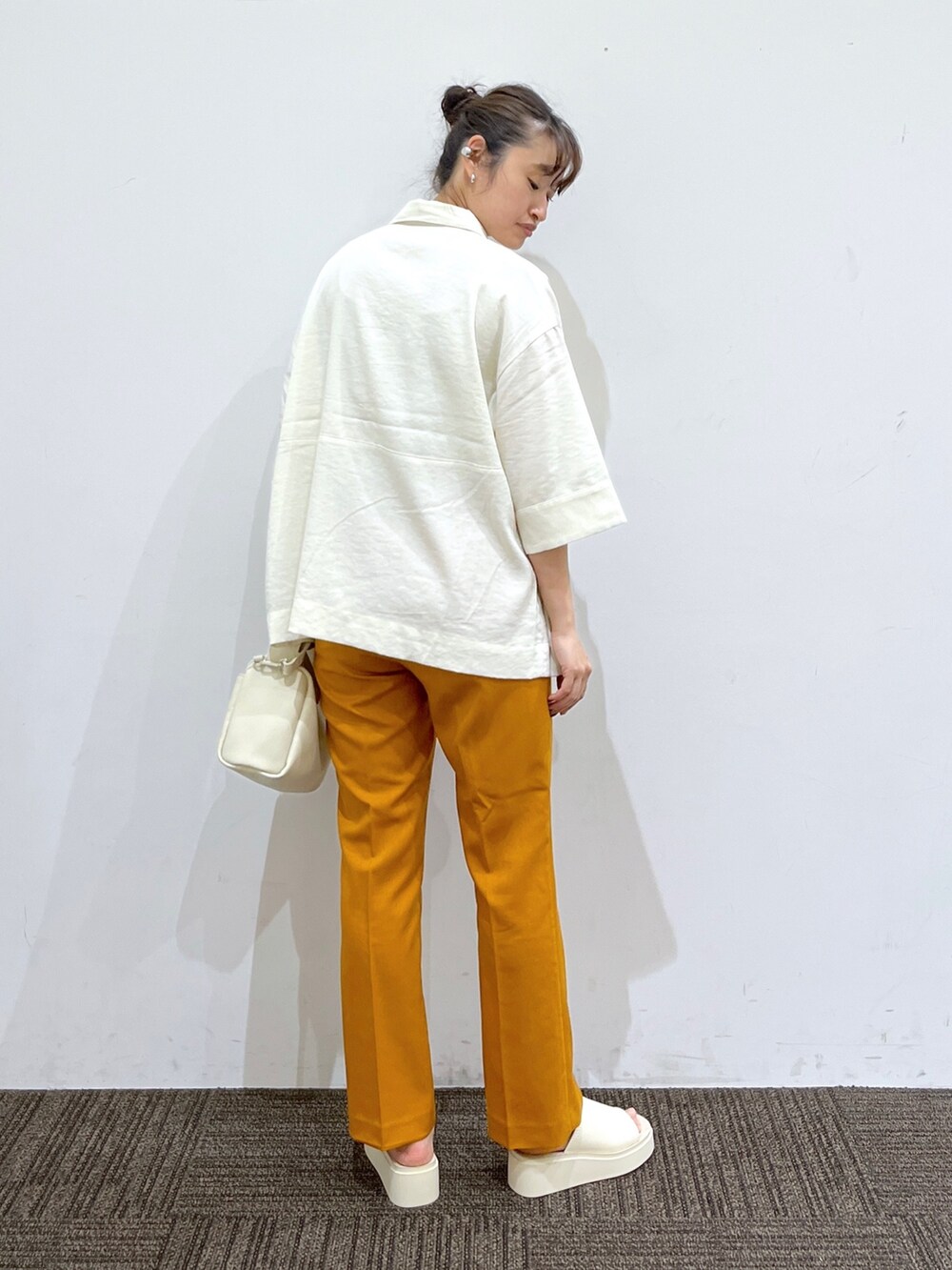 ホワイト系のサンダル、オレンジ系のその他パンツ、ホワイト系のショルダーバッグを着用したレディースの春コーディネートの3枚目の写真