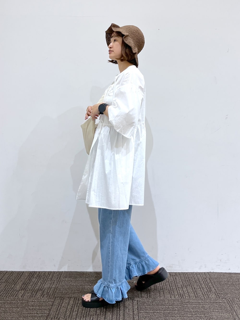 ホワイト系のバッグ、ブルー系のデニムパンツ、ホワイト系のシャツ/ブラウスを着用したレディースの春コーディネートの2枚目の写真