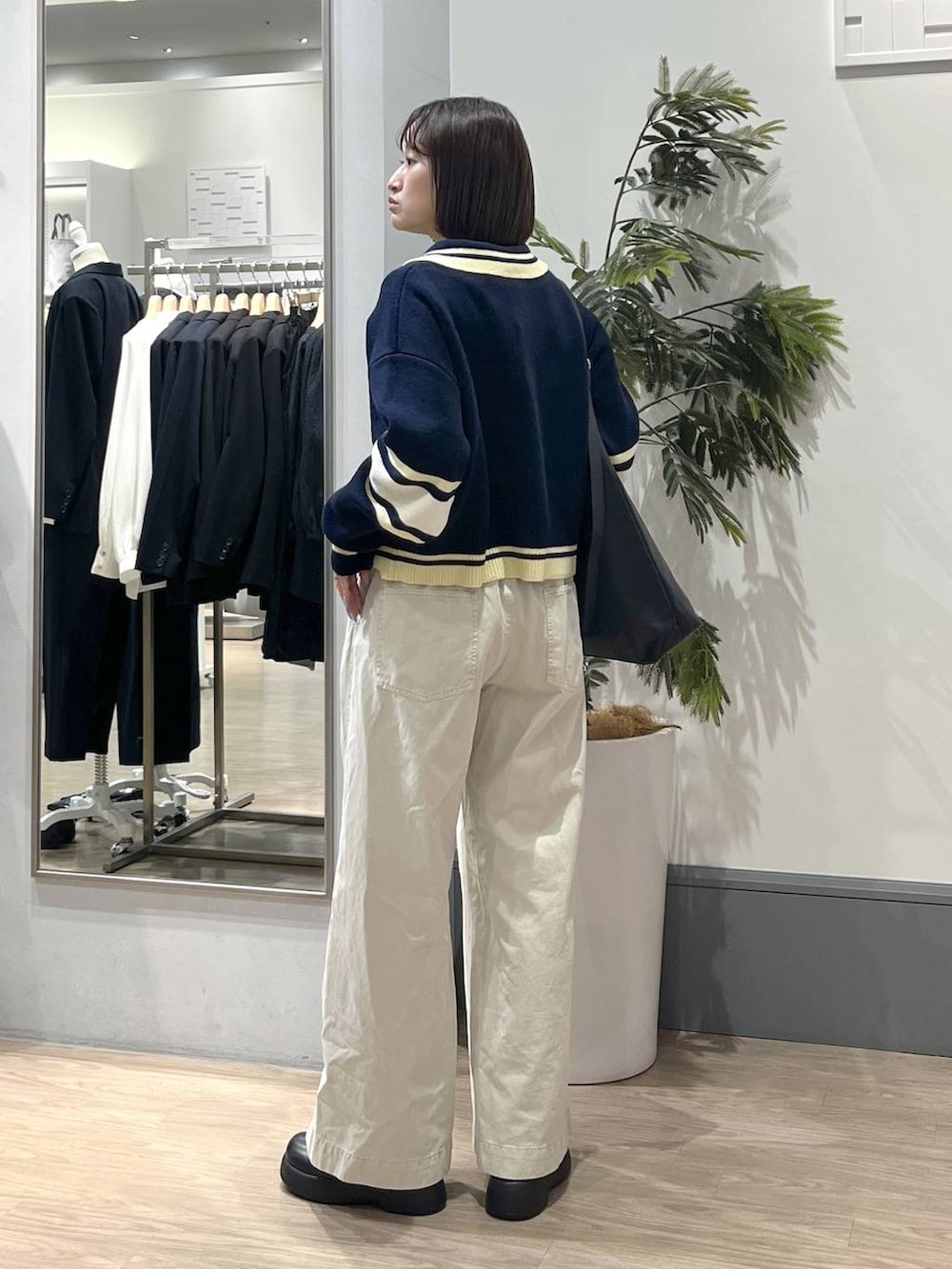 ブラック系のショルダーバッグ、ブラック系のTシャツ/カットソー、ホワイト系のデニムパンツを着用したレディースの冬コーディネートの4枚目の写真