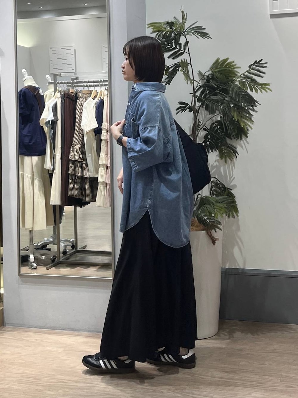 グレー系のTシャツ/カットソー、ブルー系のシャツ/ブラウス、ブラック系のトートバッグを着用したレディースの春コーディネートの2枚目の写真