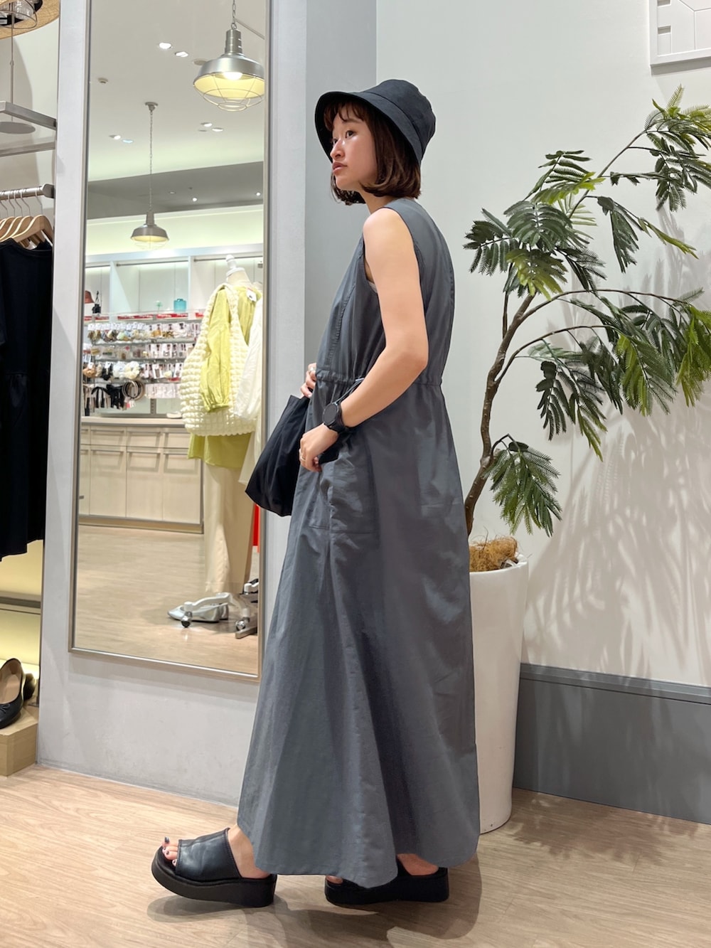 グレー系のワンピース、ブラック系のショルダーバッグ、ブラック系のシューズを着用したレディースの夏コーディネートの2枚目の写真