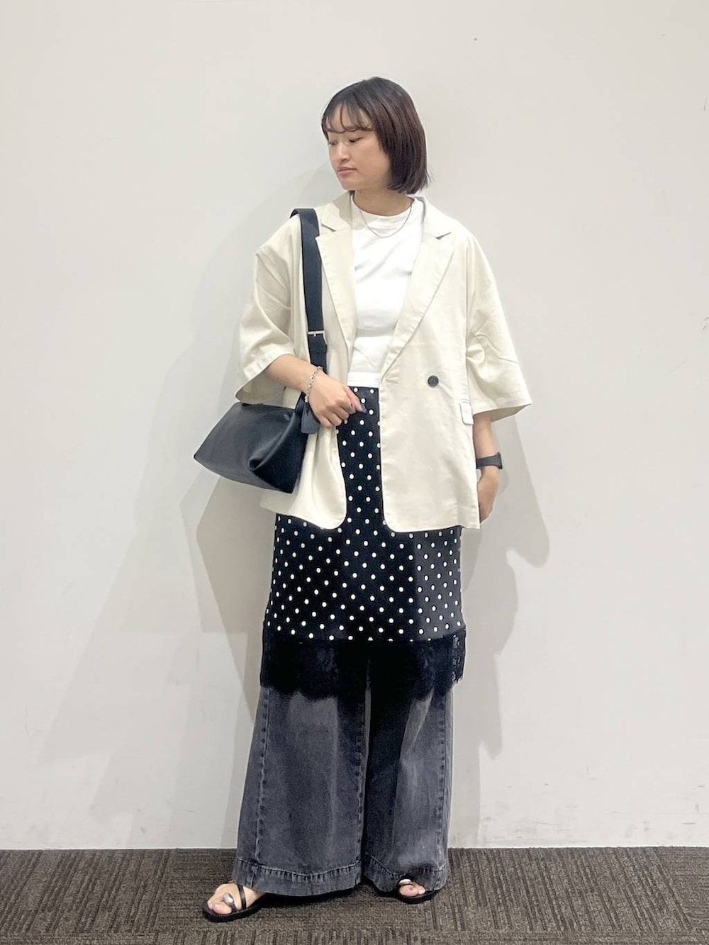 ブラック系のデニムパンツ、ホワイト系のテーラードジャケット、ホワイト系のTシャツ/カットソーを着用したレディースの夏コーディネートの2枚目の写真