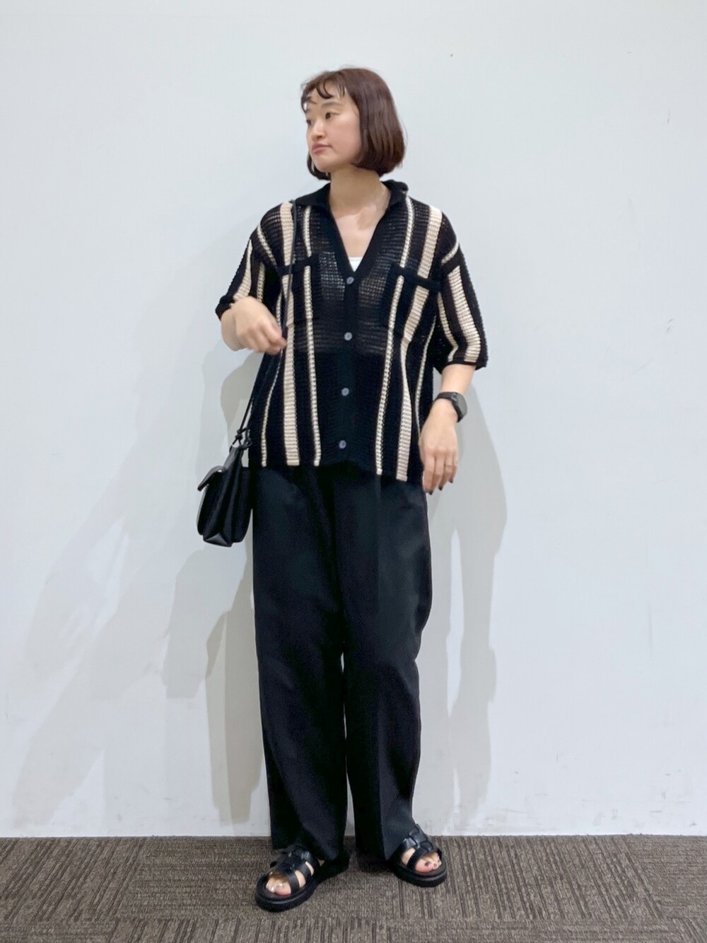 ブラック系のトップス、ホワイト系のトップス、ブラック系のパンツを着用したレディースの春コーディネートの2枚目の写真