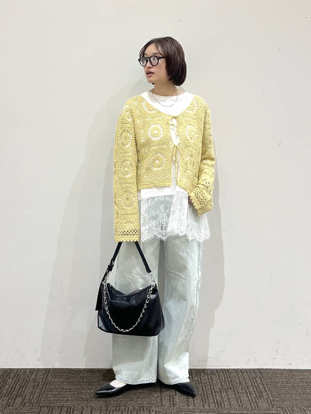 ブラック系のパンプス、ブルー系のデニムパンツ、ブラック系のショルダーバッグを着用したレディースの春コーディネートの2枚目の写真