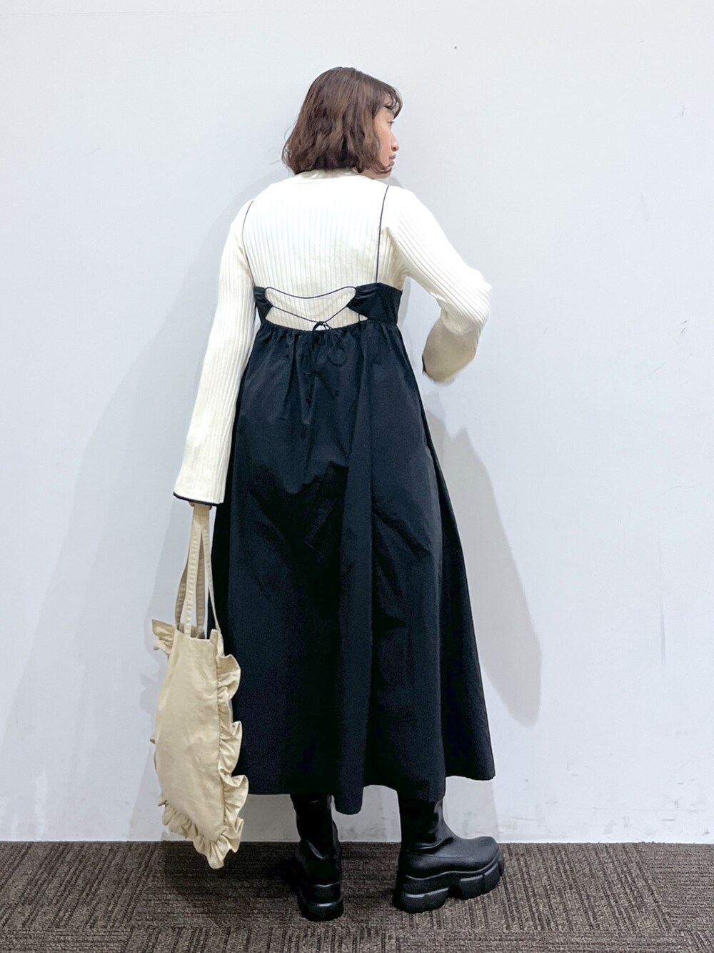 ブラック系のワンピース/ドレス、ホワイト系のトップス、ベージュ系のバッグを着用したレディースの冬コーディネートの3枚目の写真