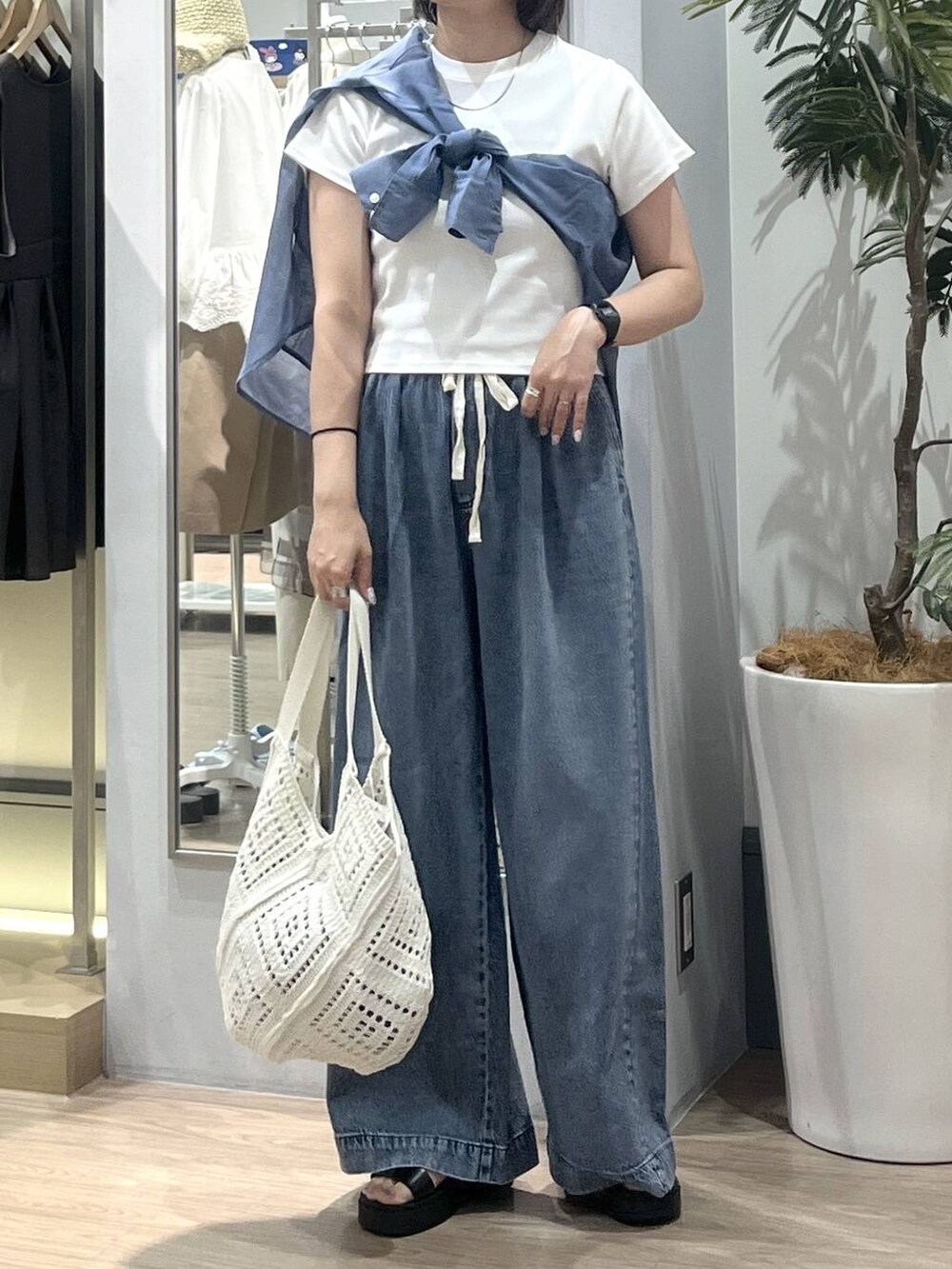 ブルー系のデニムパンツ、ブルー系のシャツ/ブラウス、ホワイト系のTシャツ/カットソーを着用したレディースの夏コーディネートの2枚目の写真