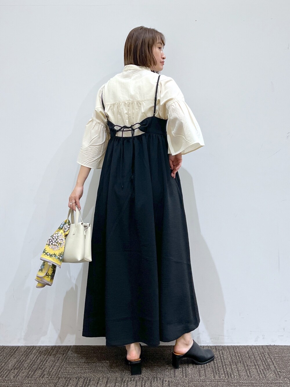 ブラック系のワンピース/ドレス、ホワイト系のトップス、ホワイト系のバッグを着用したレディースの春コーディネートの3枚目の写真