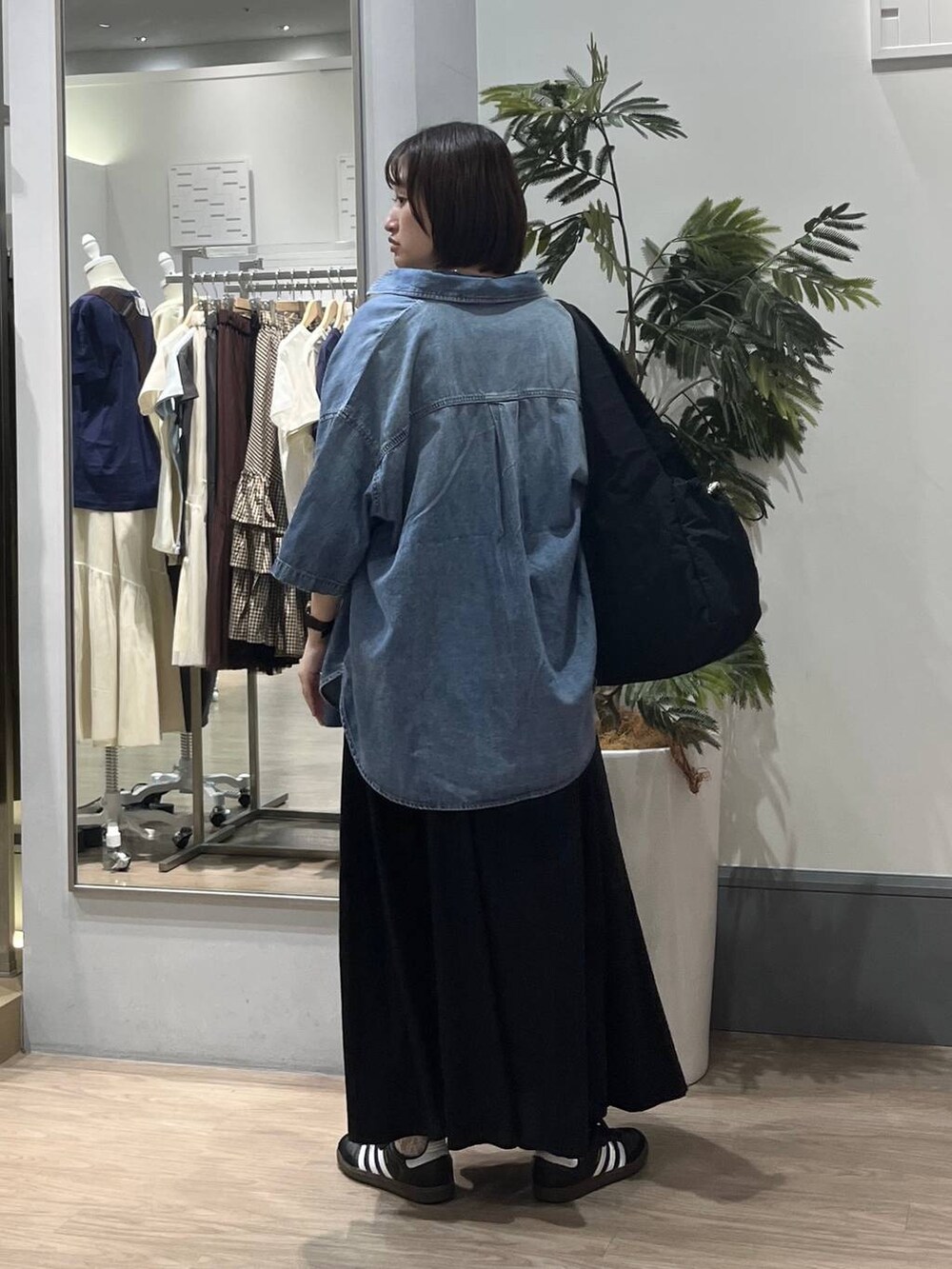 グレー系のTシャツ/カットソー、ブルー系のシャツ/ブラウス、ブラック系のトートバッグを着用したレディースの春コーディネートの3枚目の写真