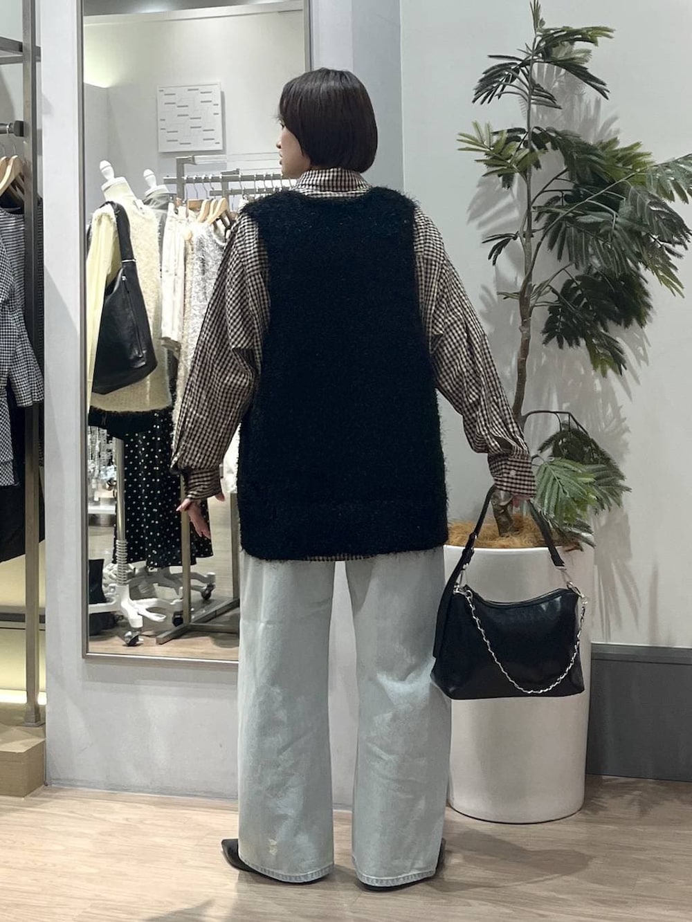 ブラック系のパンプス、ブルー系のデニムパンツ、ブラック系のショルダーバッグを着用したレディースの冬コーディネートの4枚目の写真