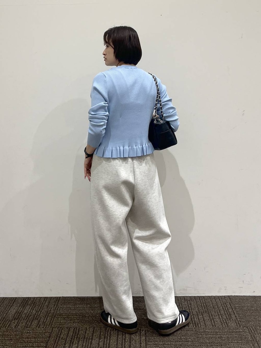 グレー系のスウェットパンツ、ブラック系のショルダーバッグ、ブルー系のTシャツ/カットソーを着用したレディースの冬コーディネートの4枚目の写真