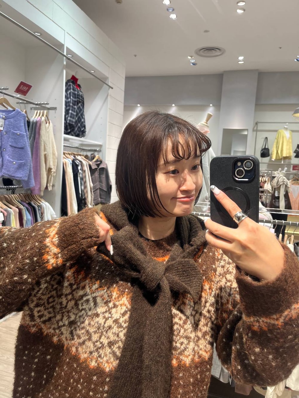 ブラウン系のニット/セーター、ブラウン系のマフラーを着用したレディースの冬コーディネートの2枚目の写真