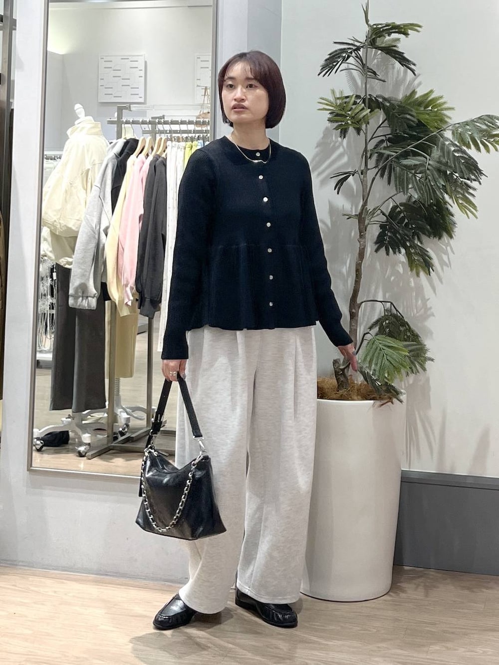 グレー系のスウェットパンツ、ブラック系のショルダーバッグ、ブラック系のローファーを着用したレディースの春コーディネートの2枚目の写真