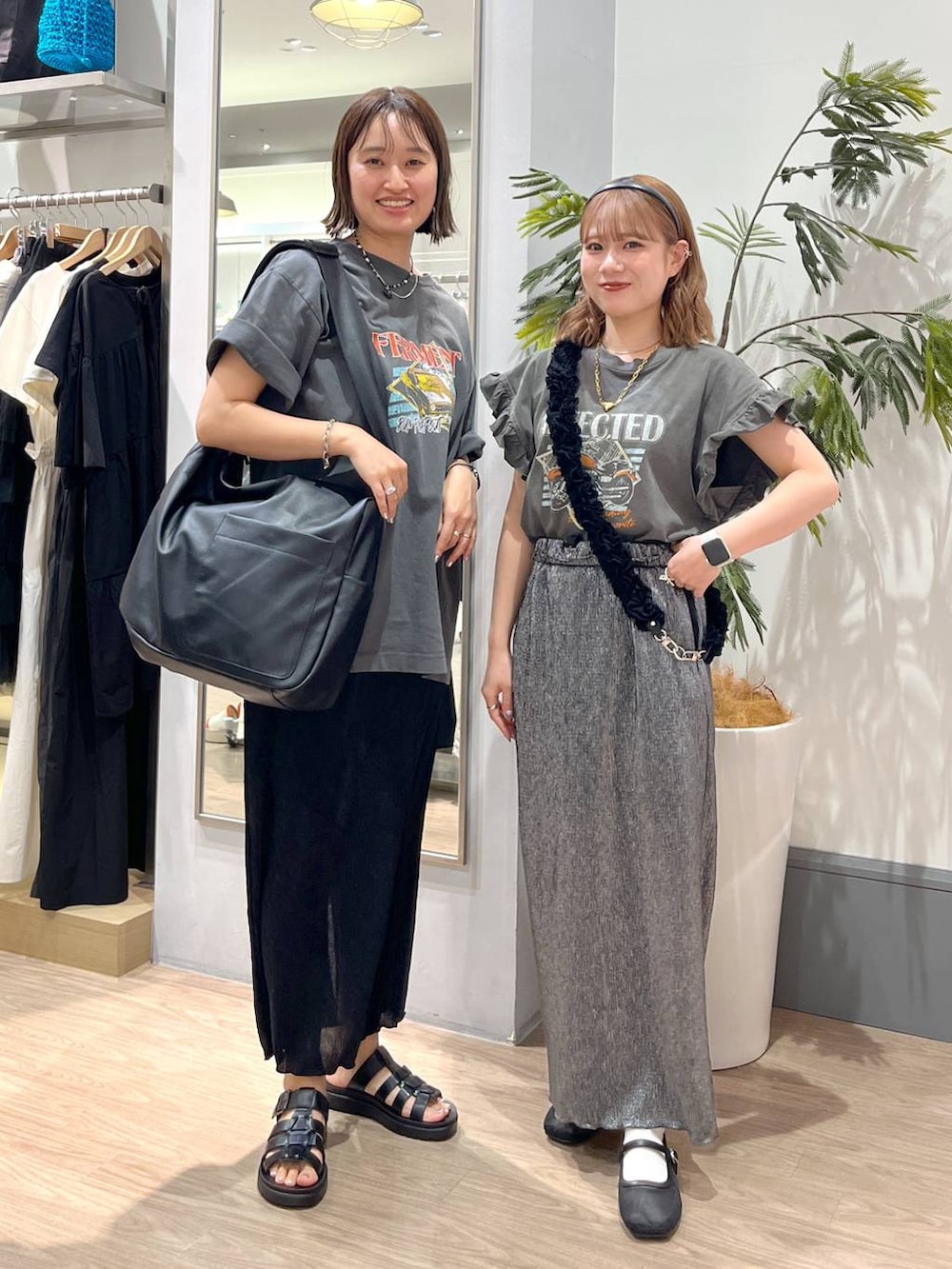 ブラック系のボディバッグ/ウエストポーチ、ブラック系のスニーカー、グレー系のTシャツ/カットソーを着用したレディースの春コーディネートの2枚目の写真