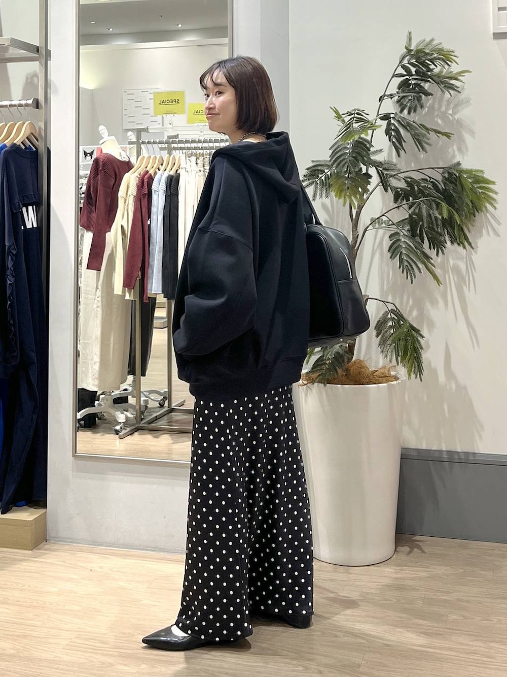 ブラック系のスカート、ブラック系のパーカー、ホワイト系のTシャツ/カットソーを着用したレディースの秋コーディネートの3枚目の写真