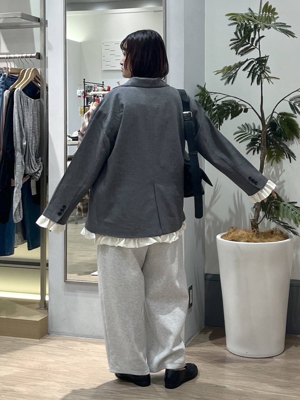 ブラック系のショルダーバッグ、ブラック系のローファー、グレー系のスウェットパンツを着用したレディースの秋コーディネートの4枚目の写真