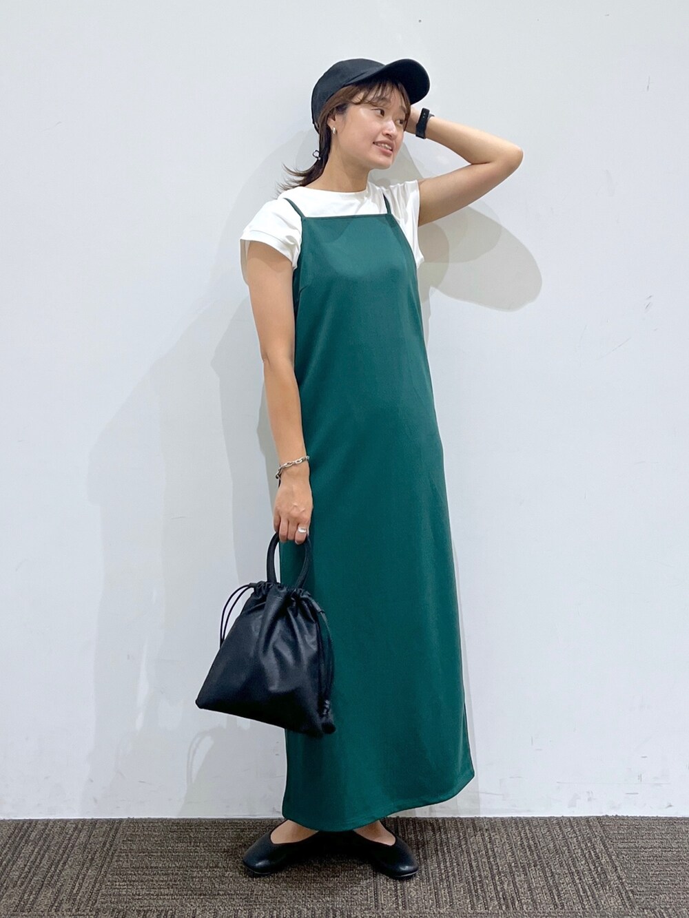 グリーン系のワンピース、ホワイト系のTシャツ/カットソー、ブラック系のショルダーバッグを着用したレディースの夏コーディネートの2枚目の写真