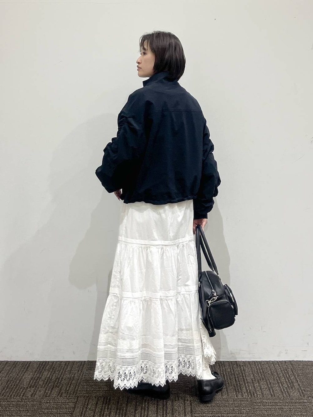 ホワイト系のTシャツ/カットソー、ブラック系のボストンバッグ、ブラック系のローファーを着用したレディースの春コーディネートの4枚目の写真